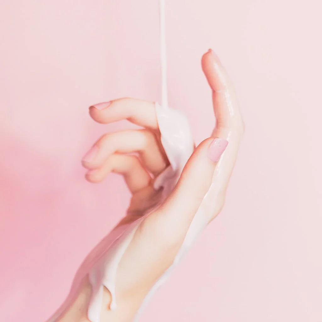 purple background with a hand in front with its index finger up having melted soap dripping down the hand