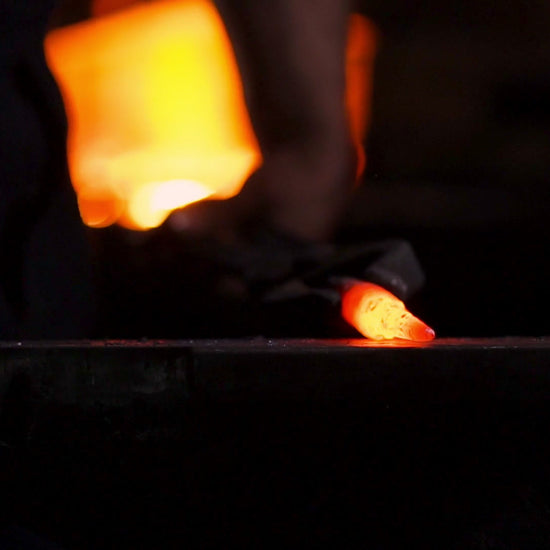 Blacksmith hitting an anvil and then a sun coming out behind the Earth.